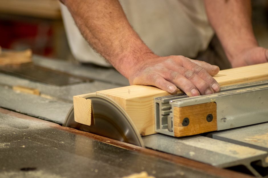 Master carpenter crafting wood kitchen cabinets in a workshop