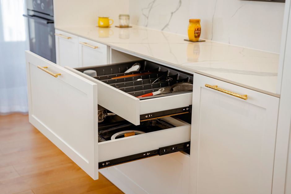 Open kitchen cabinet drawers showing organizational layout